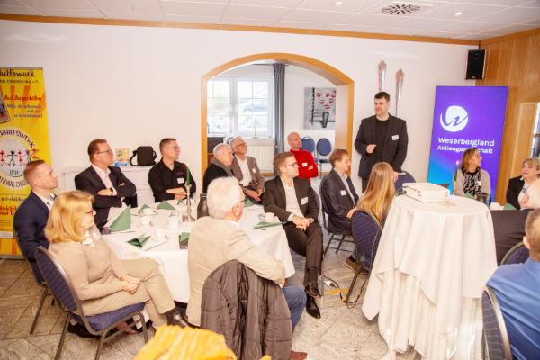 Gruppe sitzt an Tischen beim Vortrag „Cyberkriminaltät“ - beim 75. Unternehmerfrühstück der Weserbergland AG